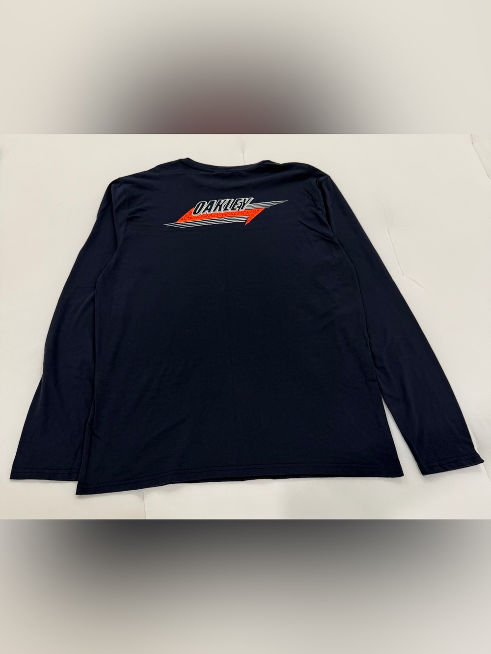 Oakley Navy Blue Long Sleeve Tee with Orange and White Back Logo.